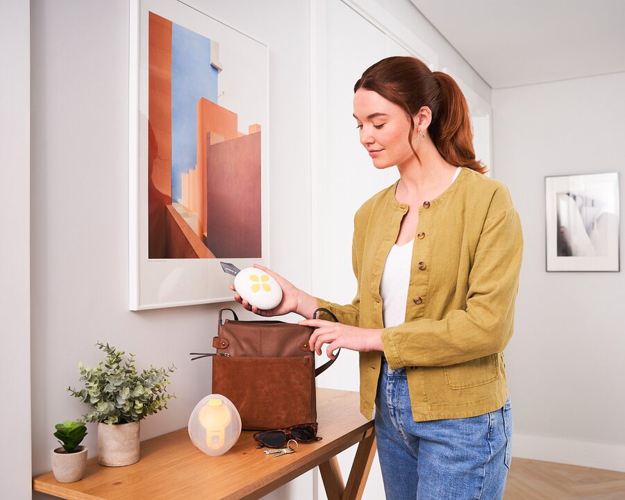 Mama stopt de Medela Solo™ Hands-free enkele elektrische borstkolf in haar tas | © Solo™ Hands-free single electric breast pumps