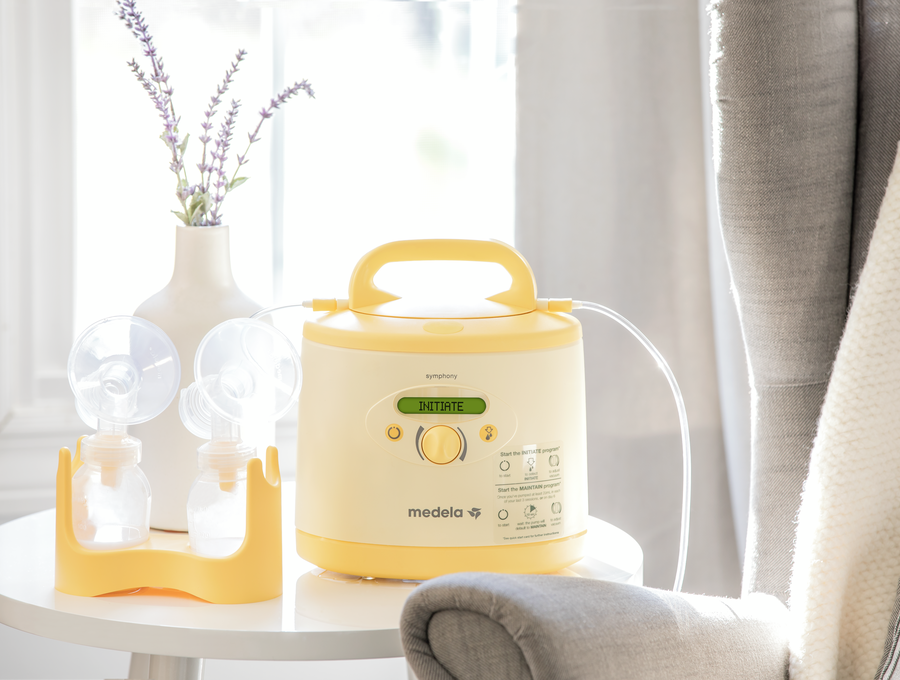 Thuis liggen een Medela Symphony PLUS® borstkolf en een kolfset op tafel.