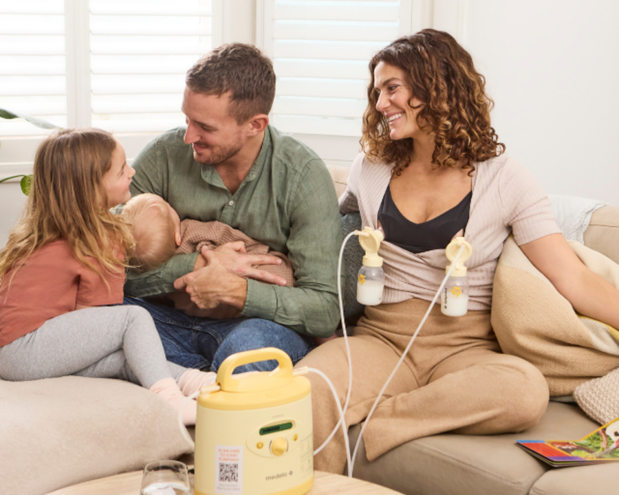Eine Mutter pumpt zu Hause mit einer gemieteten Medela Symphony® Milchpumpe ab, während sie Zeit mit ihrer Familie verbringt.