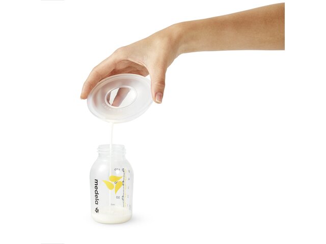 Pouring breast milk from the Medela Milk Collection Shells into a breast milk storage bottle