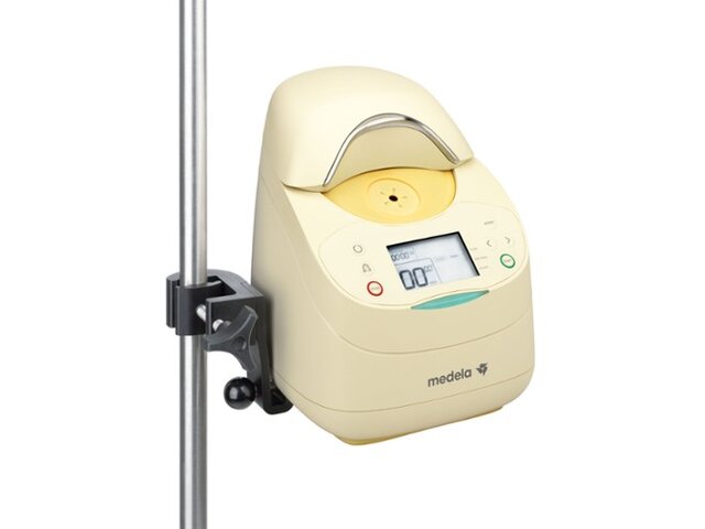 The Medela Calesca Heating and Thawing Device connected to an IV pole.