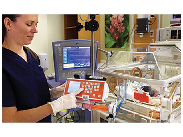 A nurse working with the Medela Enteral Feeding Pump in a hospital neonatal ward.