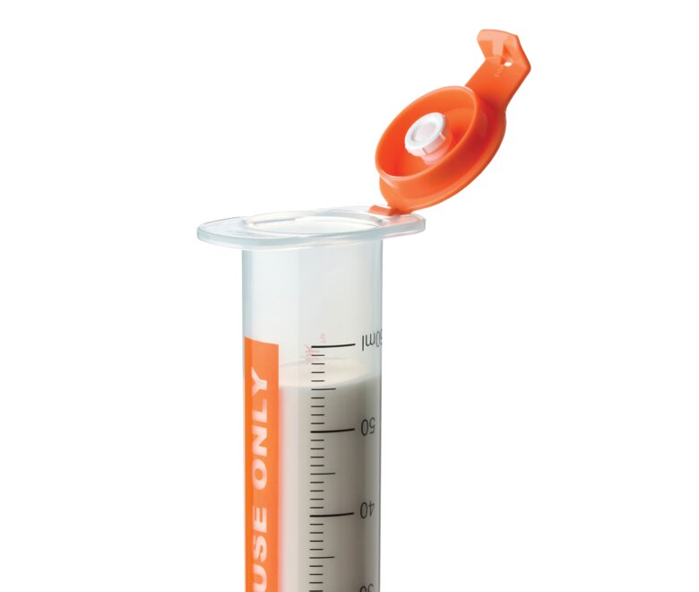 A Medela GraviFeed® Syringe with ENFit® Connector and hydrophobic filter built into the lid.