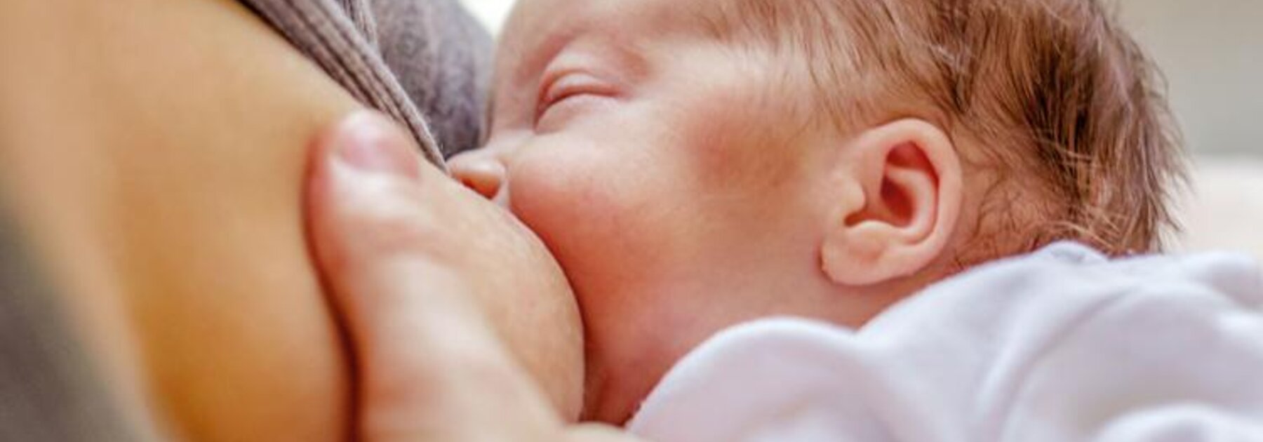 Close-up of a mom breastfeeding her newborn baby.
