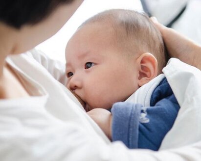 A mother cradles her baby while breastfeeding.