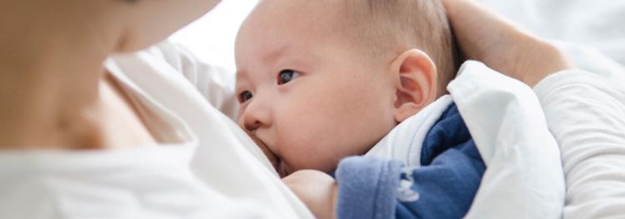 A mother cradles her baby while breastfeeding.