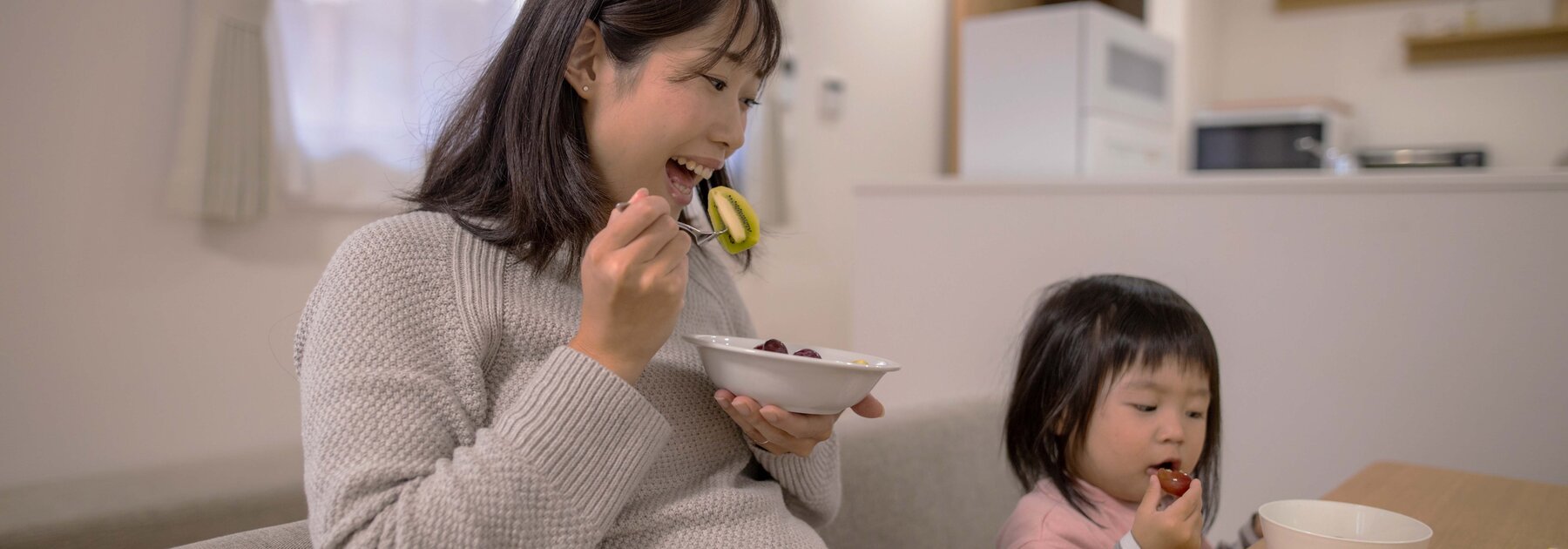 Zwangere vrouw geniet van een gezonde maaltijd en benadrukt het belang van voeding tijdens de zwangerschap.
