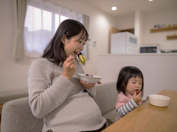 Zwangere vrouw geniet van een gezonde maaltijd en benadrukt het belang van voeding tijdens de zwangerschap.