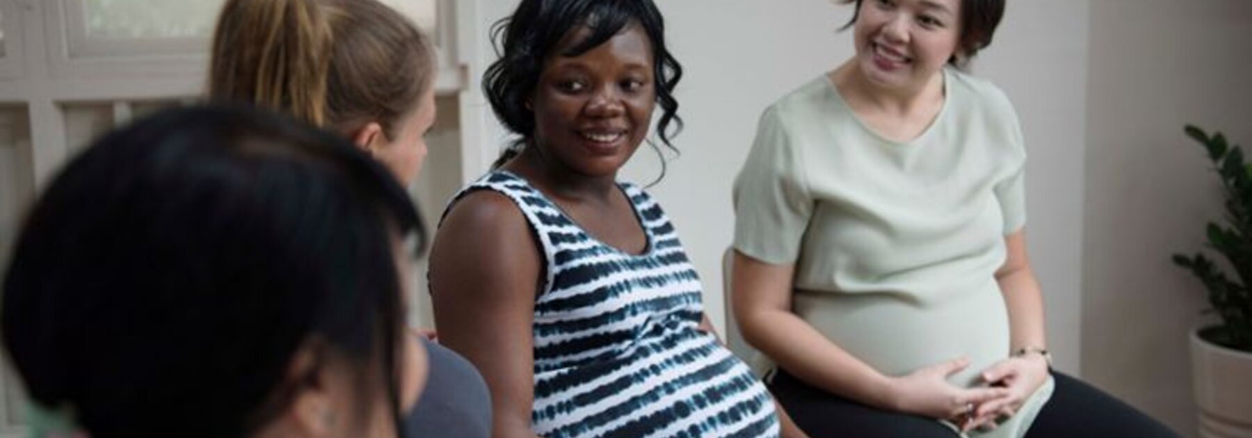 Pregnant women talk together in a group.