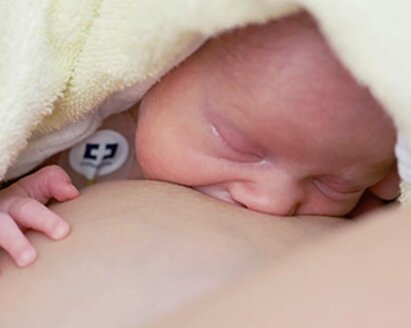 Newborn baby initiating breastfeeding with mother in hospital