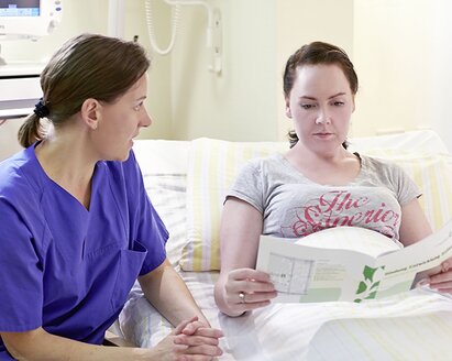 A nurse gives a mother information about mastitis.