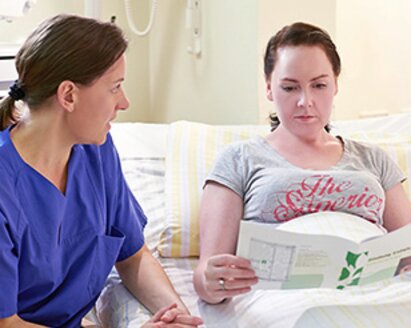 A nurse gives a mother information about mastitis.