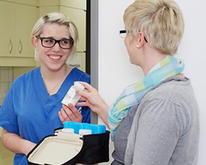 Two women in a hospital with breast milk in storage bottles in a Medela Cooler Bag.