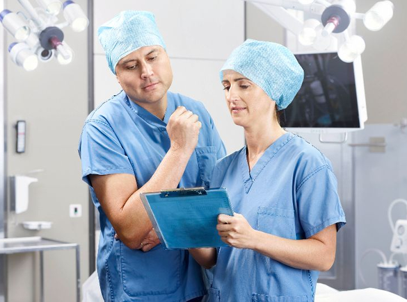 Een arts en verpleegster bespreken een medische behandeling in een operatiekamer.