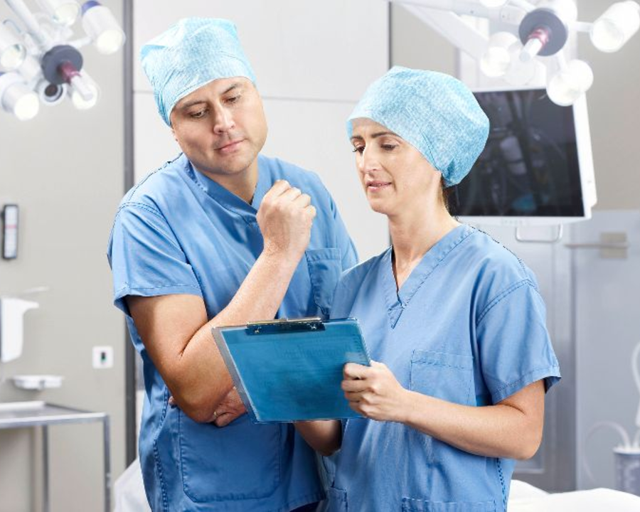 Een arts en verpleegster bespreken een medische behandeling in een operatiekamer.