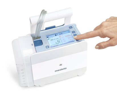 Die Hand berührt die Oberseite des Medela Thopaz Plus