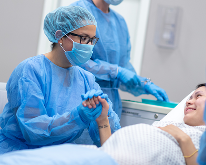 Operating room with doctor holding pregnant mother's hand