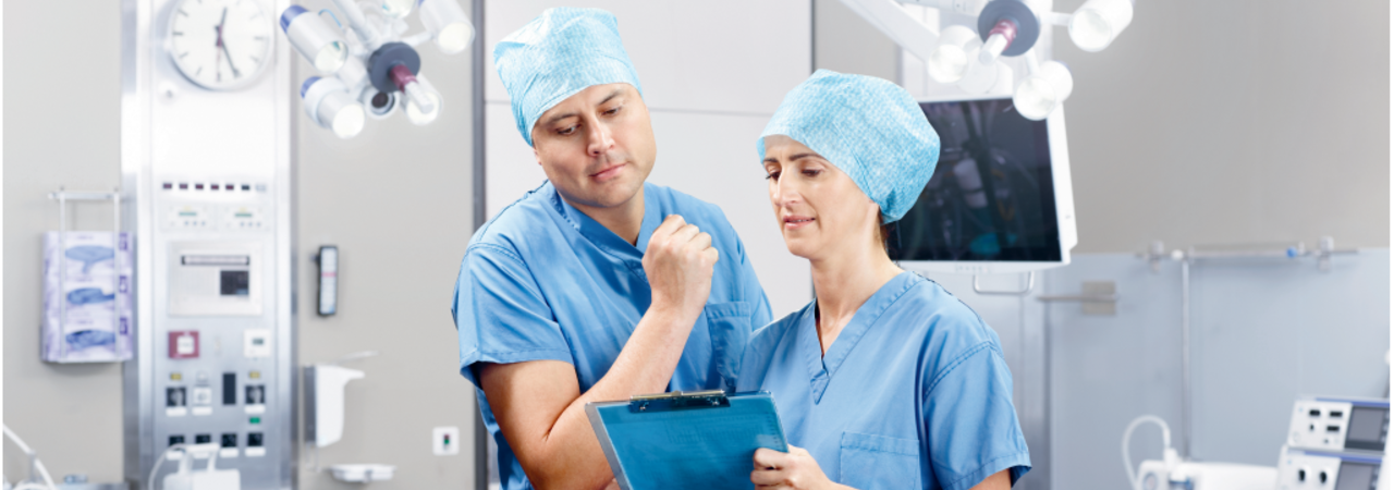 A doctor and nurse discuss medical treatment in an operating room.