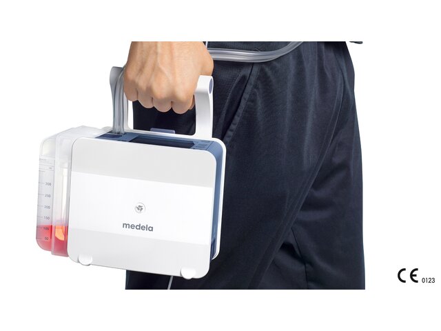 Carried by the handle, a man uses the portable Medela Thopaz+ digital chest drainage and monitoring system.