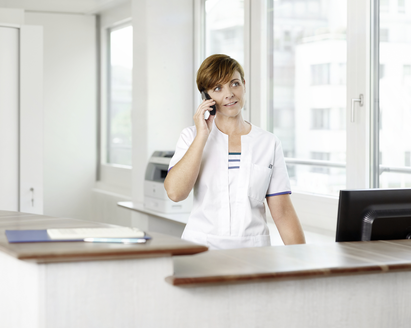 A healthcare professional in an office on the phone.