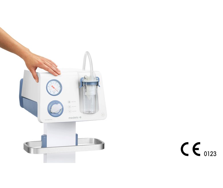 Die Hand einer Person ruht auf der Medela Dominant Flex chirurgischen Saugpumpe über dem Vakuummeter.