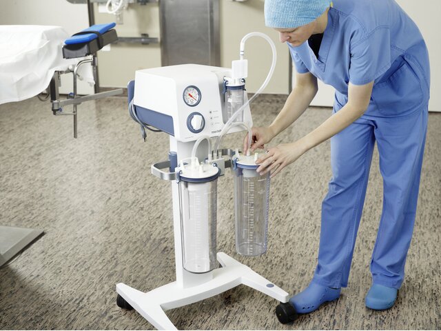 A doctor in a hospital using a Medela Reusable Collection System (RCS).