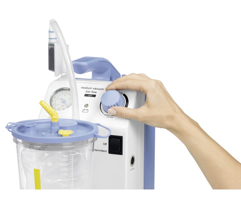 Close-up of a hand adjusting the vacuum setting on a Medela Vario suction pump.