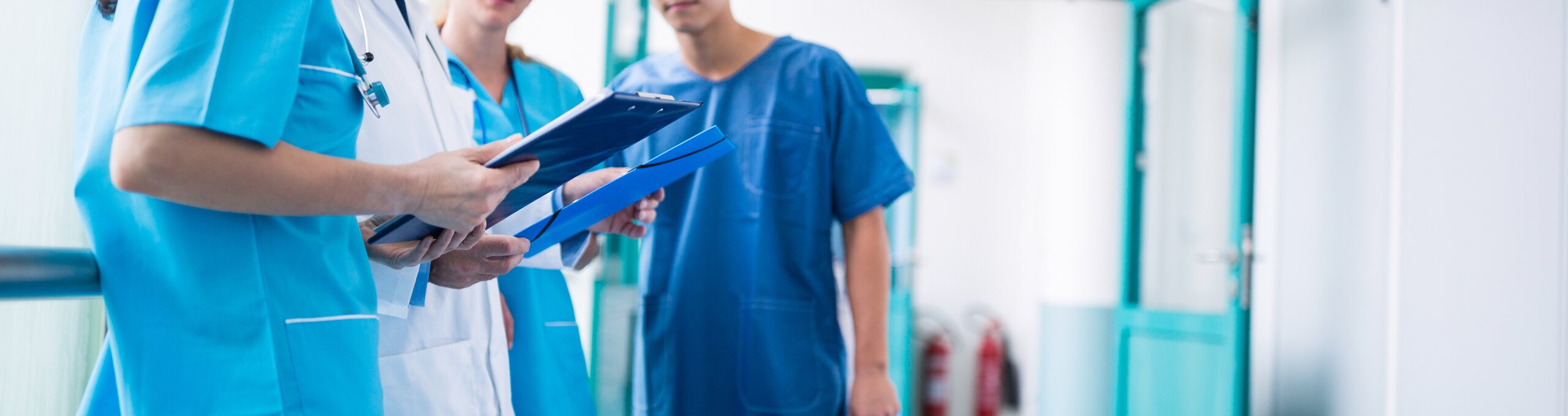 Medical staff in a hospital talking in a corridor.