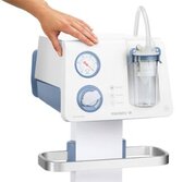 A person's hand rests on the Medela Dominant Flex surgical suction pump above the vacuum meter gauge.