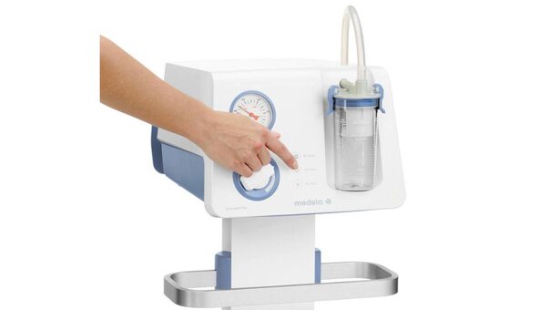 Image of a user's hand turning on the Medela Dominant Flex Surgical Suction Pump