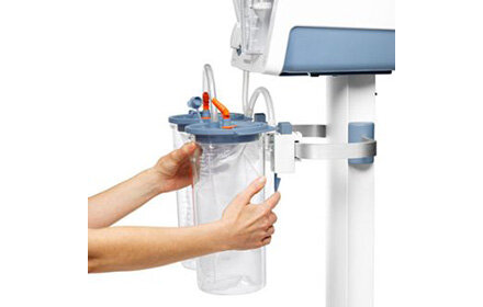 A person's hands release the Clamp Holder that attaches a disposable suction jar to a standard rail, for use with a Medela surgical suction pump.