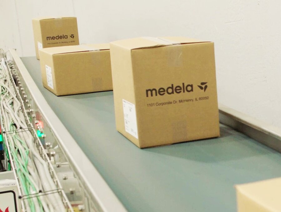 Dozen met het label “Medela” op een lopende band.