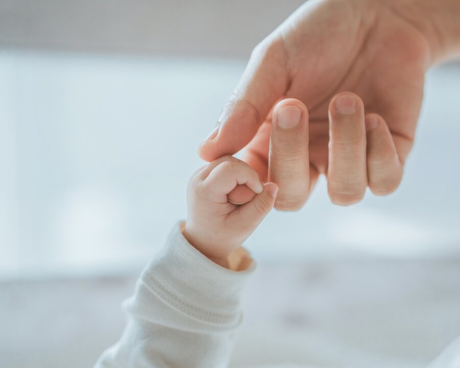 Twee lactatiekundigen kijken uit op een moeder die haar pasgeboren baby vasthoudt.