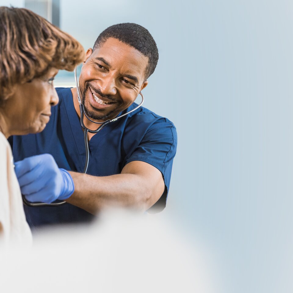 Doctor listening to a woman's heart with a stethoscope 