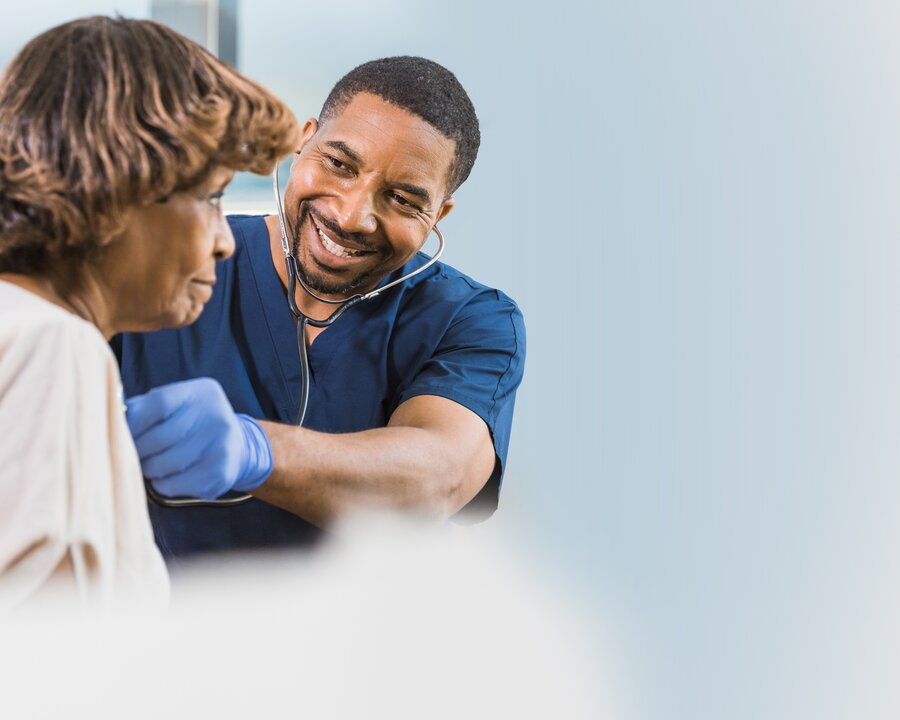 Médecin écoutant le cœur d'une femme à l'aide d'un stéthoscope