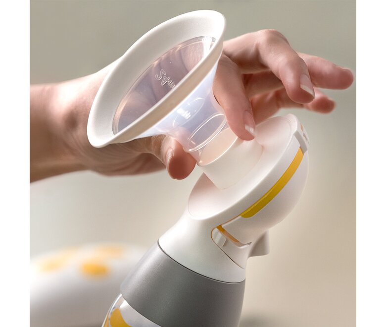 De handen van een persoon demonstreren hoe het Medela PersonalFit Flex™ borstschild bevestigd en verwijderd moet worden.