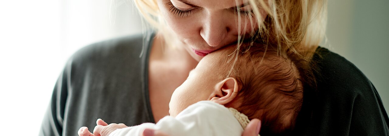 baby being burped to reduce spit-up, with helpful tips and insights from Medela