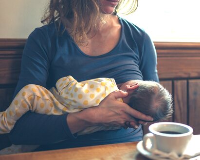 Una madre allatta il suo bambino in pubblico.
