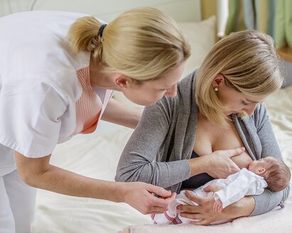 Uma consultora de lactação ensina técnicas de amamentação a uma mãe.