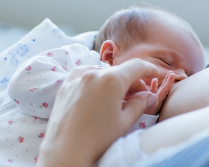 Um grande plano de uma mãe a amamentar a sua filha.