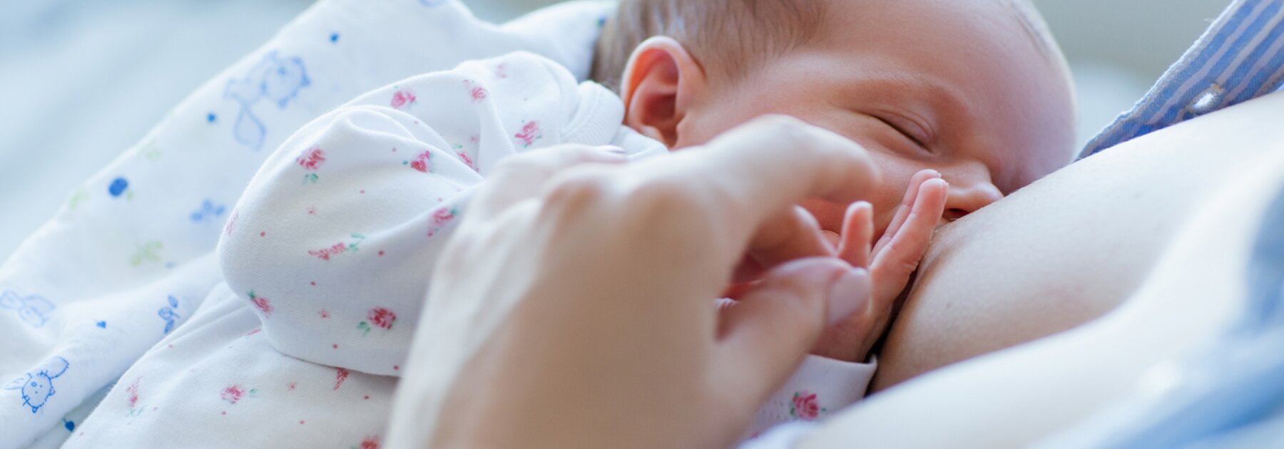 A close-up of a mom breastfeeding her baby-girl.