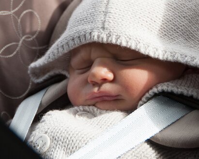 Un bebé duerme en su sillita.