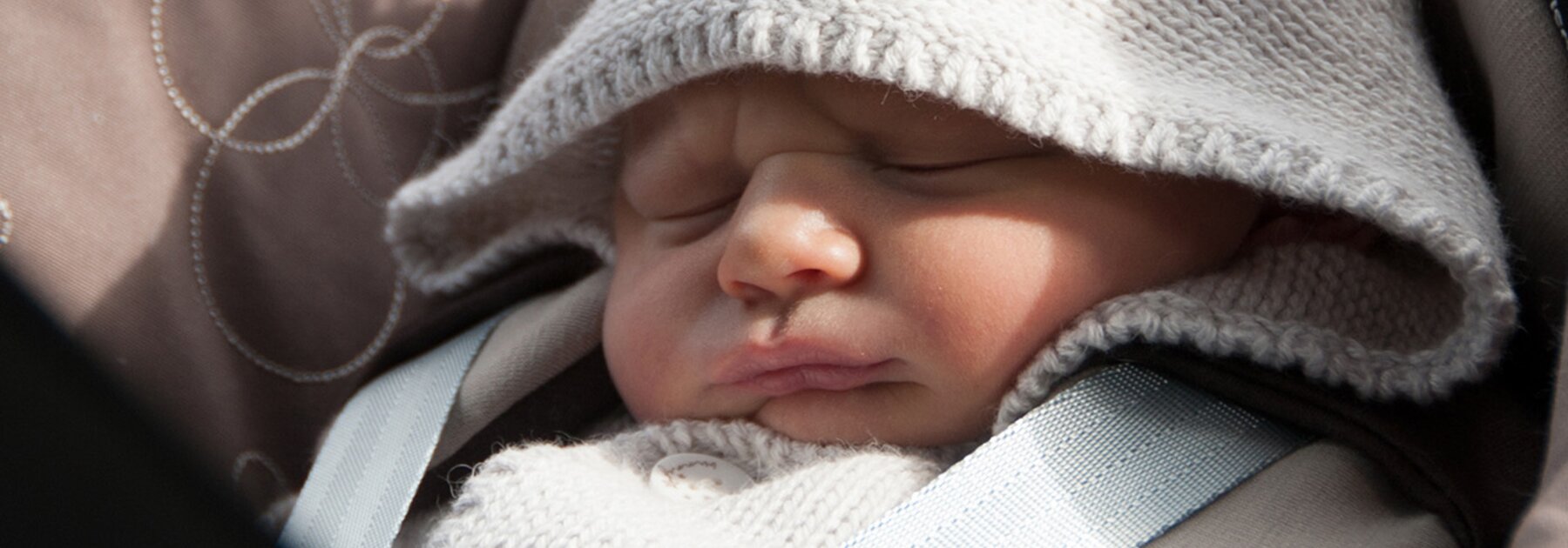 Ein Baby schläft in seinem Autositz.
