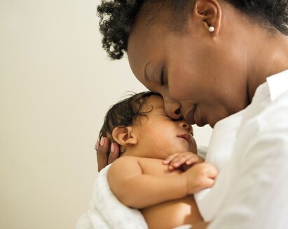 Mother holding newborn baby face-to-face.