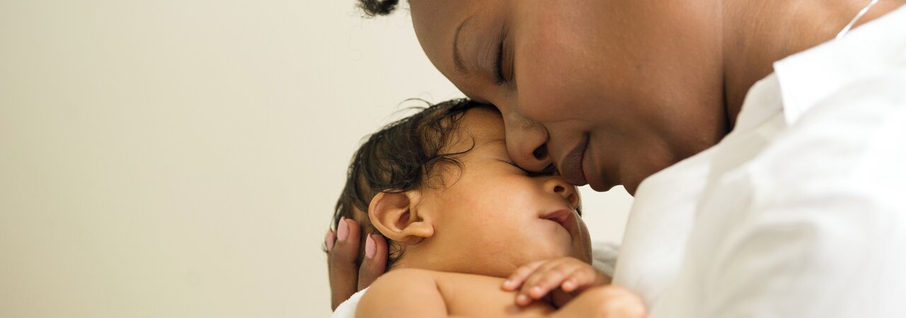 Mother holding newborn baby face-to-face.