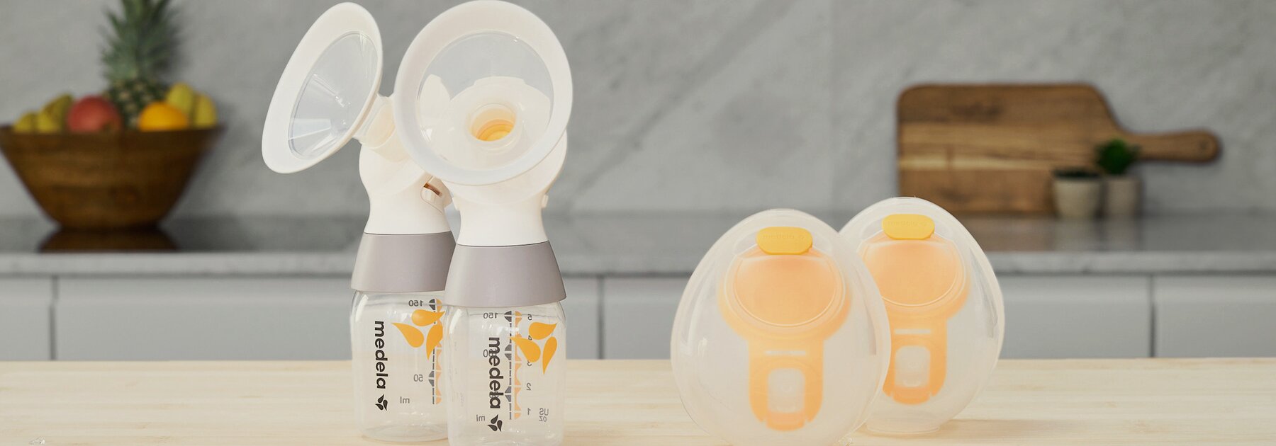 Een set Medela Hands-free opvangbekers met een Medela klassieke PersonalFit Flex™ dubbele kolfset, tubes niet afgebeeld, zittend op een aanrecht.