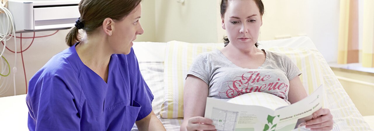 A nurse gives a mother information about mastitis.